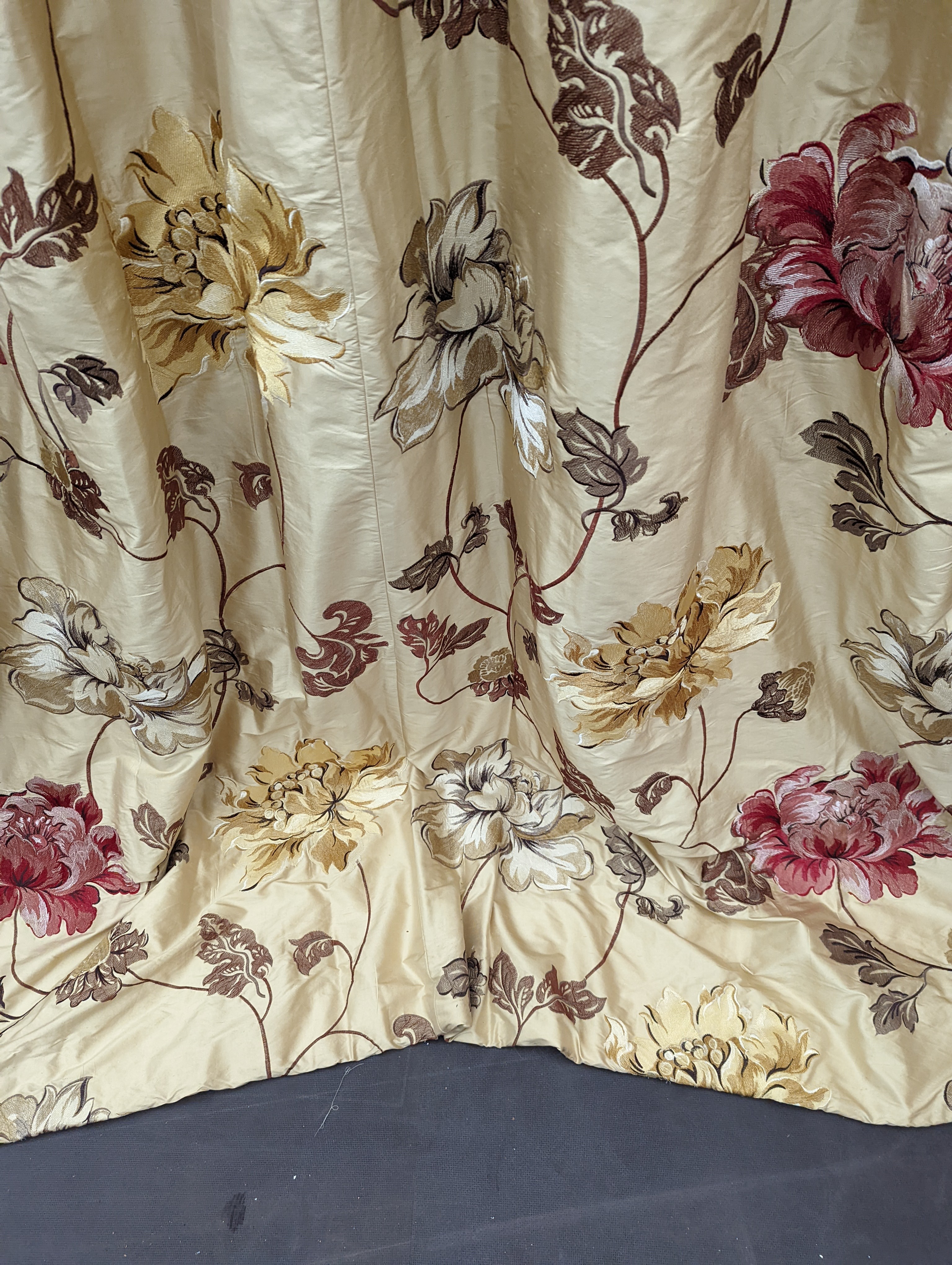 A pair of floral lined curtains. Approximate measurements: Width of top 110cm, Width of bottom 220cm Length 250cm